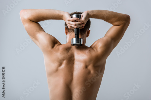 back view of shirtless sportsman using barbell isolated on grey