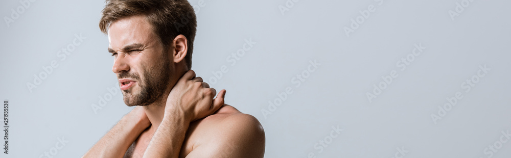 Fototapeta premium panoramic shot of sportsman with neck pain isolated on grey