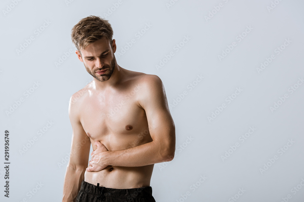 shirtless bearded man with stomach pain isolated on grey