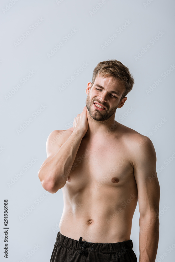 shirtless bearded man with neck pain isolated on grey