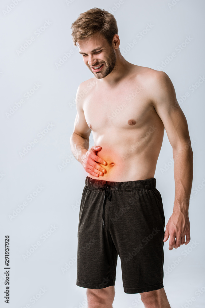 shirtless sportman with abdominal pain isolated on grey
