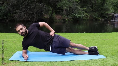 Man doing side plank in park