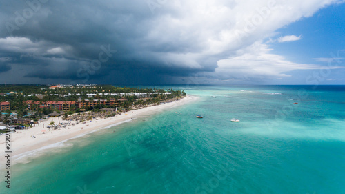 stunning panorama of the blue sea and yellow sand with palm trees, beautiful green palm trees on the shore, aerial view from a flying drone, shooting from a copter, Punta Cana, Dominican Republic