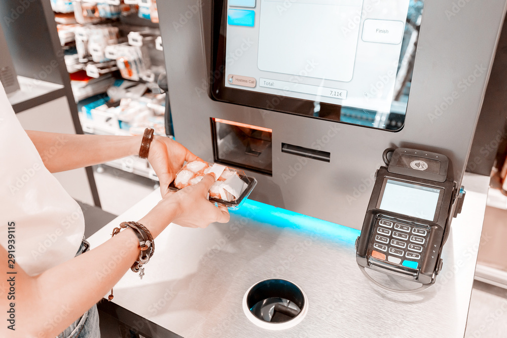 Φωτογραφία The girl in the supermarket buys sushi and makes a purchase at the checkout self