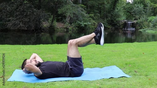 Man sit ups legs up in park