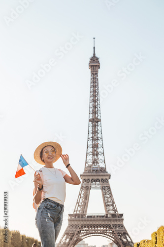 Happy asian woman traveler posing at Mars Field at the background of majestic Eiffel tower. Tourism and lifestyle in France and Paris. Vacation in Europe. © EdNurg