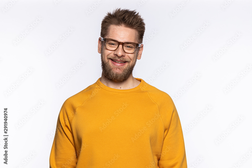 Portrait of handsome guy with stylish beard. Smiling bearded man wearing fashionable yellow sweater with copy space on it and stylish glasses. Isolated on white background Portrait of handsome guy with stylish beard. Smiling bearded man wearing fashionable yellow sweater with copy space on it and stylish glasses. Isolated on white background