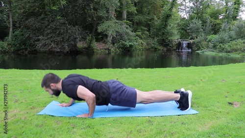 Man staggered push ups in park 