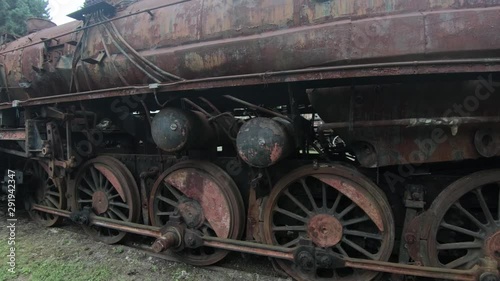 4K closeup left pan abandoned rusty locomotive steel wagons photo