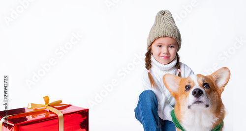 Portrait of young little girl with her pet puppy of corgi. Hugging near present. Concept christmas, new year and birthday