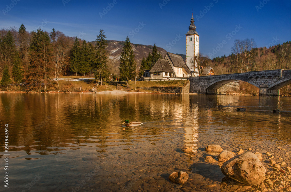 Autumn reflections on lake Bohinj, Julian Alps, the largest permanent lake in Slovenia and the Church of St. John the Baptist.