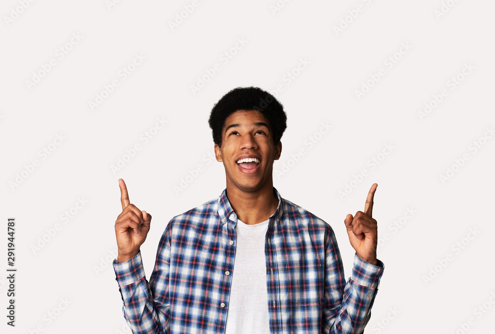 Look here! Emotional guy pointing fingers up at copy space Look here! Emotional guy pointing fingers up at copy space