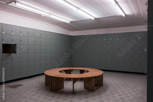 lockers in musuem with one open and round bench