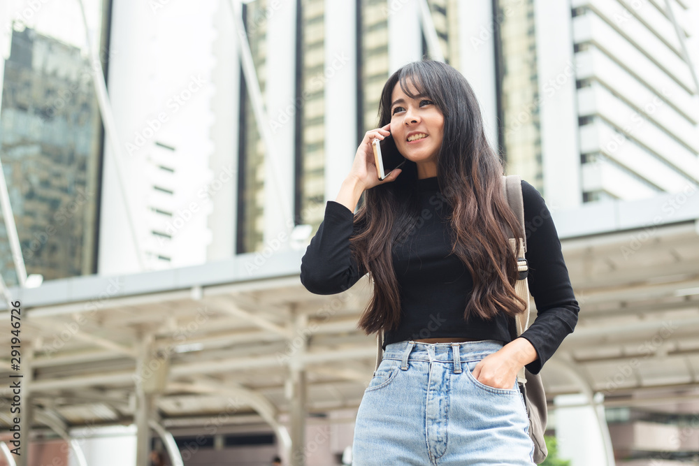 Fototapeta premium Asian young woman talking telephone in city.