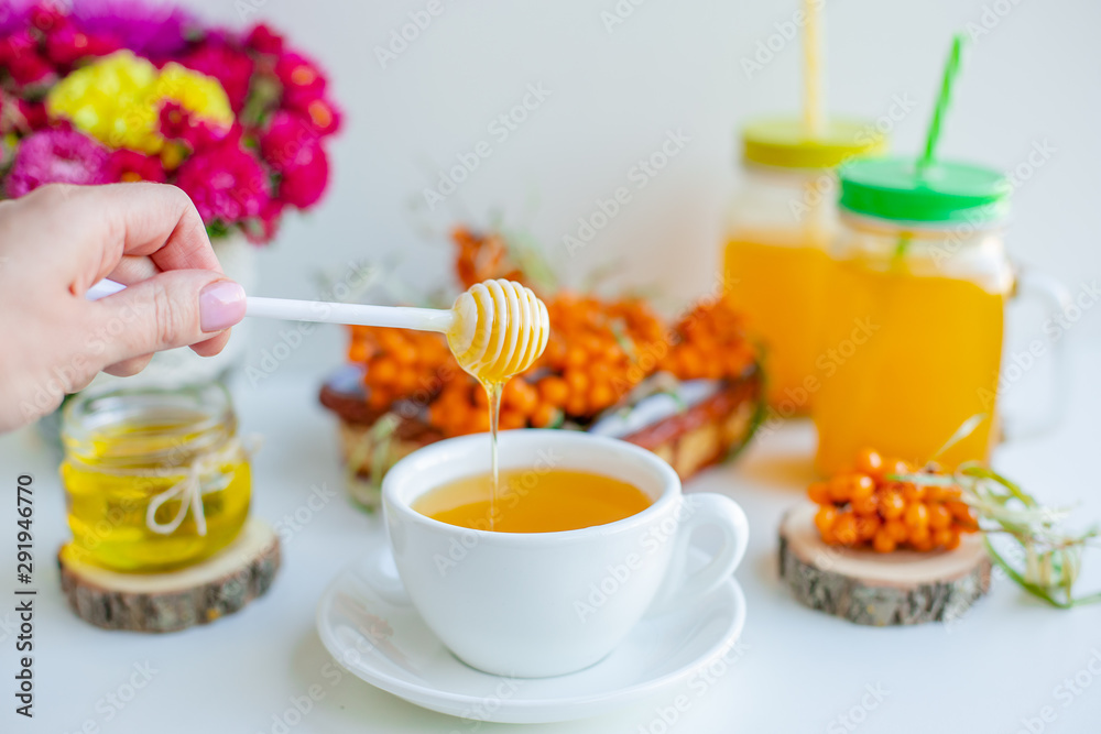 White background, natural lighting. Warm sweet organic tea with sea buckthorn berries, thyme and honey. White background, natural lighting. Warm sweet organic tea with sea buckthorn berries, thyme and honey.