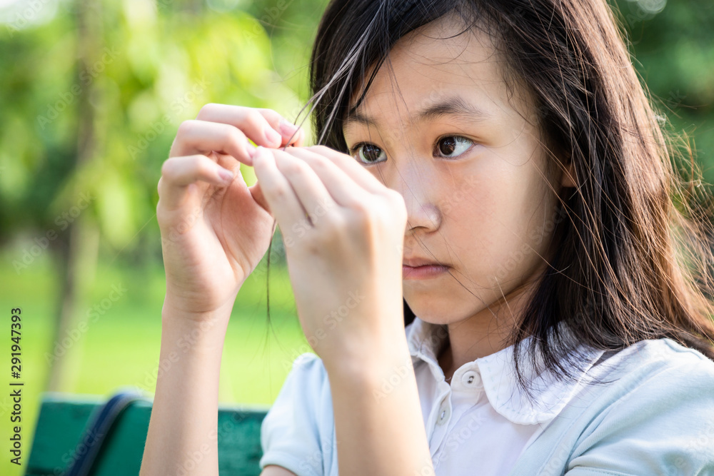 Fotka „Asian beautiful child girl pulling her hair with her fingers in