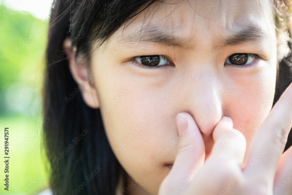 Closeup beautiful child girl pinching nose with disgust on his face due to bad smell,something stinks,female teenager gesture squeezing nose with fingers and looking at camera,bad smell situation Closeup beautiful child girl pinching nose with disgust on his face due to bad smell,something stinks,female teenager gesture squeezing nose with fingers and looking at camera,bad smell situation