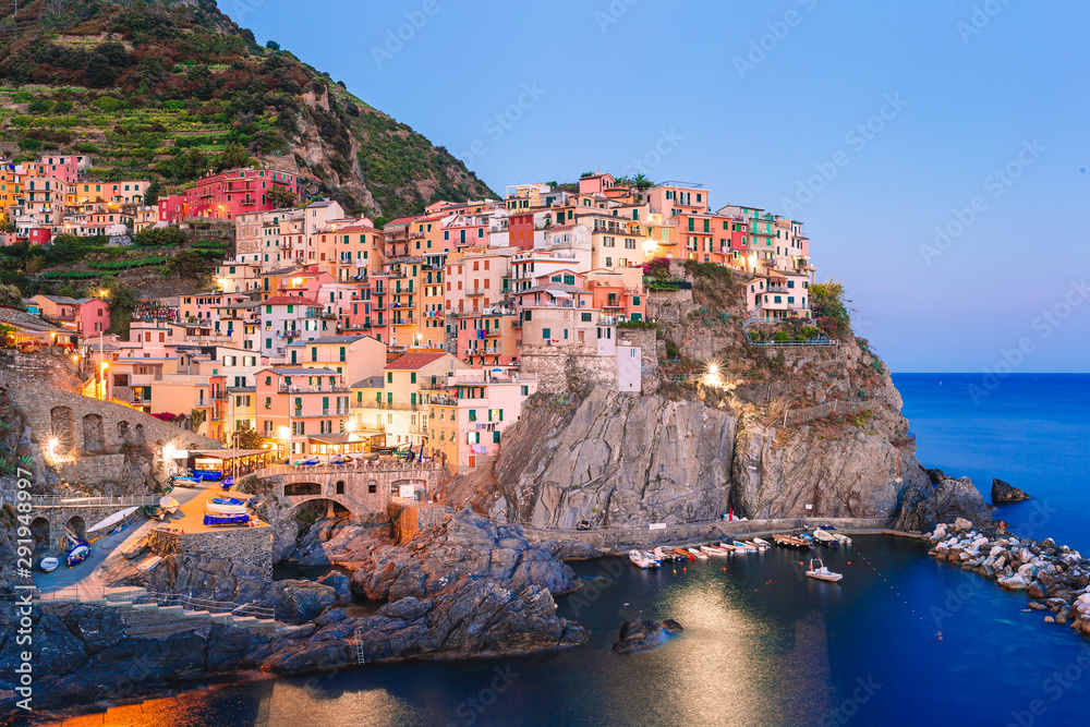 Stunning view of the beautiful and cozy village of Manarola in the Cinque Terre Reserve at sunset.