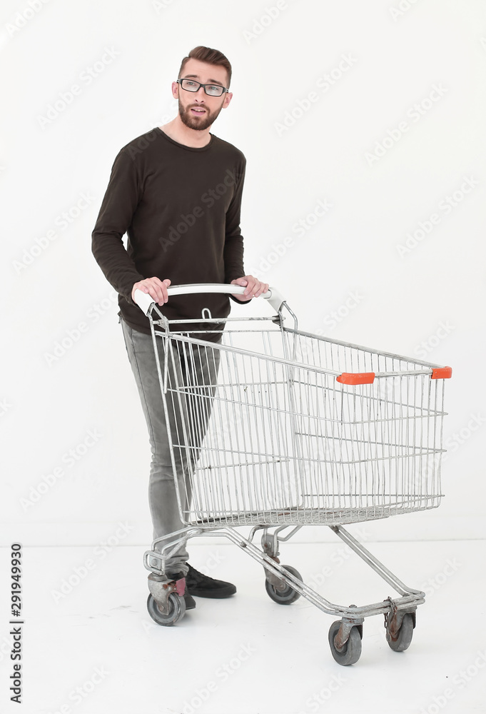 Young man with empty shopping cart, isolated on white Young man with empty shopping cart, isolated on white