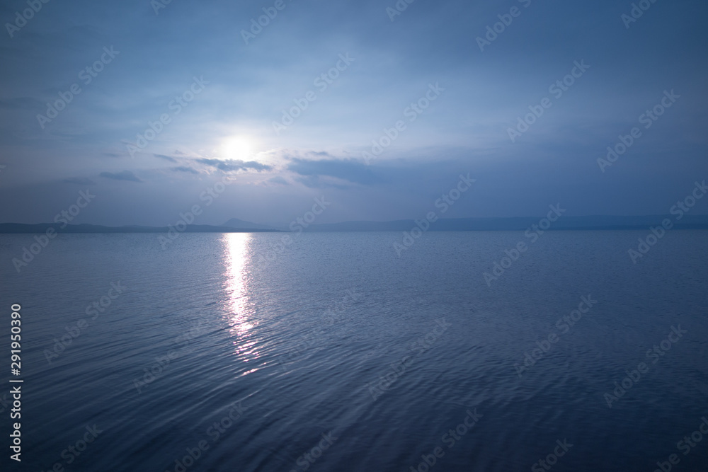 Ripples on a blue lake lit by sunset