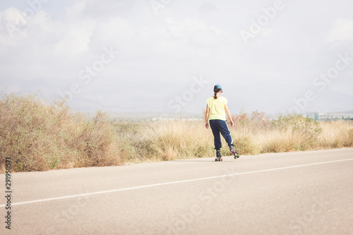 Woman skating on a lonely road in the desert