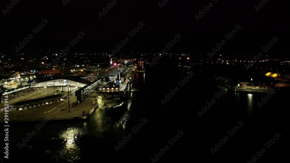 Big cruise ship with illuminated colorful lights sailing near pier at dark night. Drone shot of luxury yacht splashing waves. Big cruise ship with illuminated colorful lights sailing near pier at dark night. Drone shot of luxury yacht splashing waves.