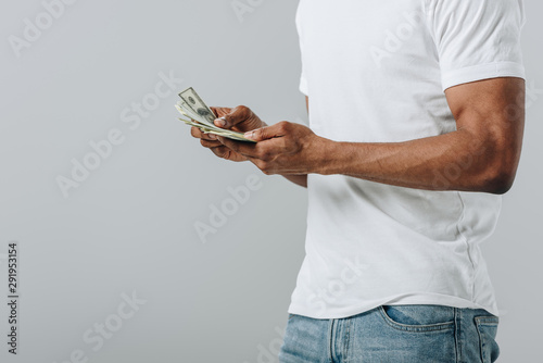 Fotografija Cropped view of African American man counting dollar banknotes isolated on grey