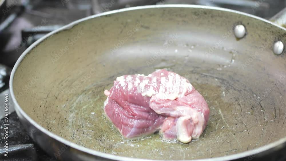 Cottura carne al sangue in una padella di un ristorante.