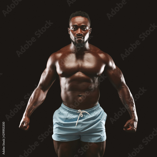 Young athletic black man showing naked muscular body