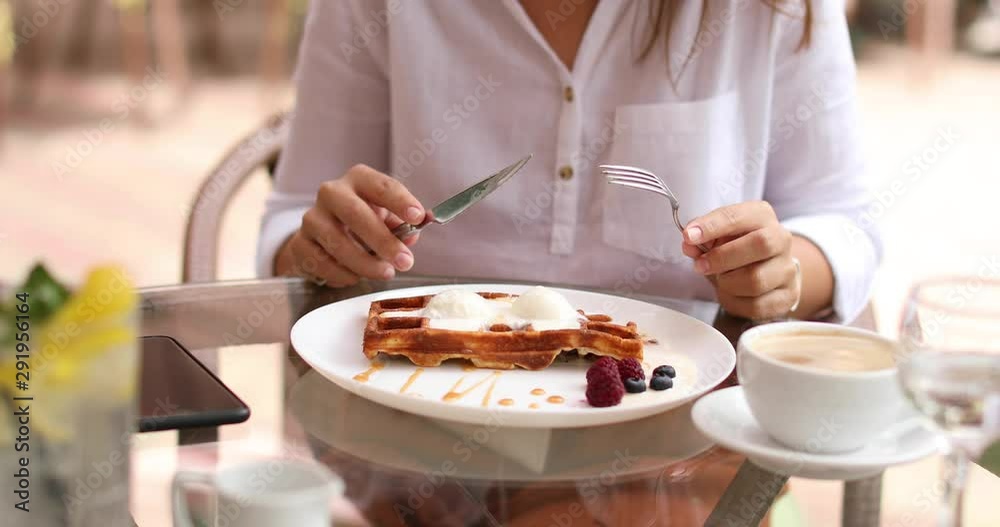 Young woman having delicious breakfast with coffee at table in cafe, closeup