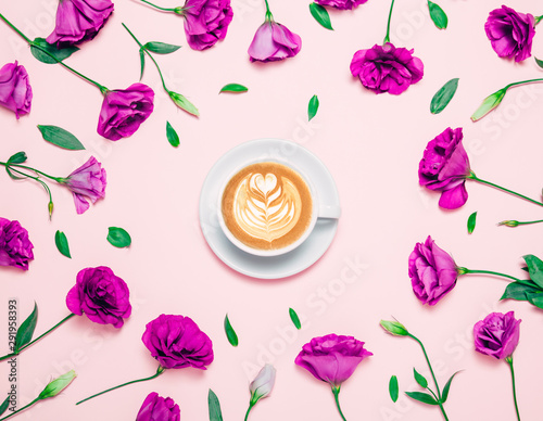 Cup of coffee abd beautiful flowers on pink background.