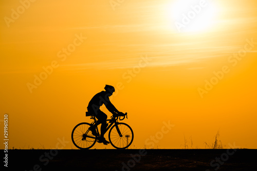Fototapeta Naklejka Na Ścianę i Meble -  Silhouette man cycling on sunset background