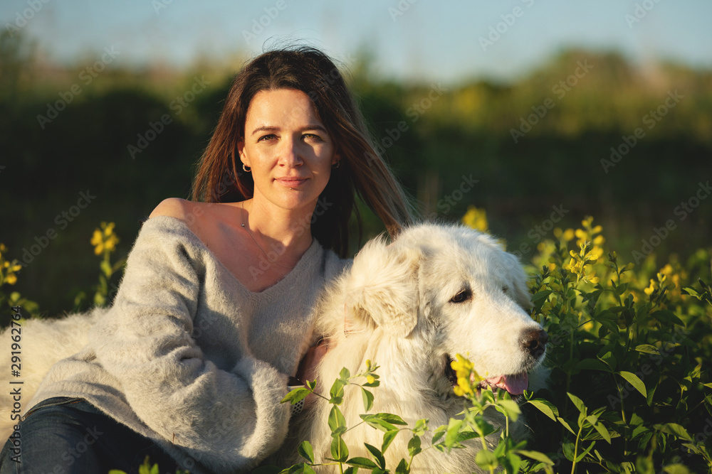 A lovely girl and Cute maremma sheepdog. Big white happy dog breed maremmano abruzzese lying in the forest in summer A lovely girl and Cute maremma sheepdog. Big white happy dog breed maremmano abruzzese lying in the forest in summer