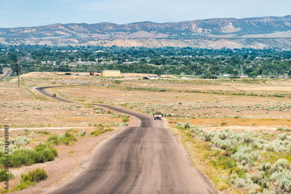 Jensen or Vernal Utah road highway with view of city near Dinosaur National Monument desert landscape