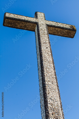A black and white decorated cross on the top of the mountain