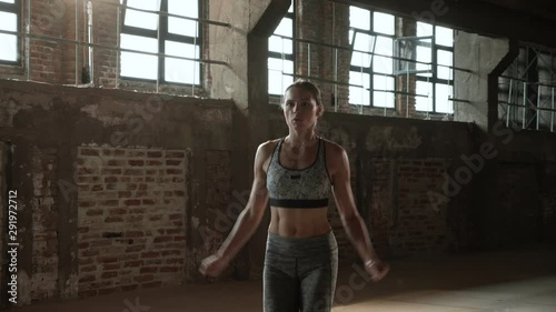 Fit woman doing jumping jack exercise at fitness gym