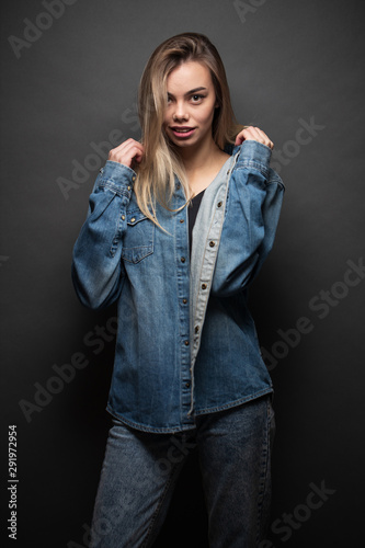 Sexy blonde girl wearing jeans clothes over gray background