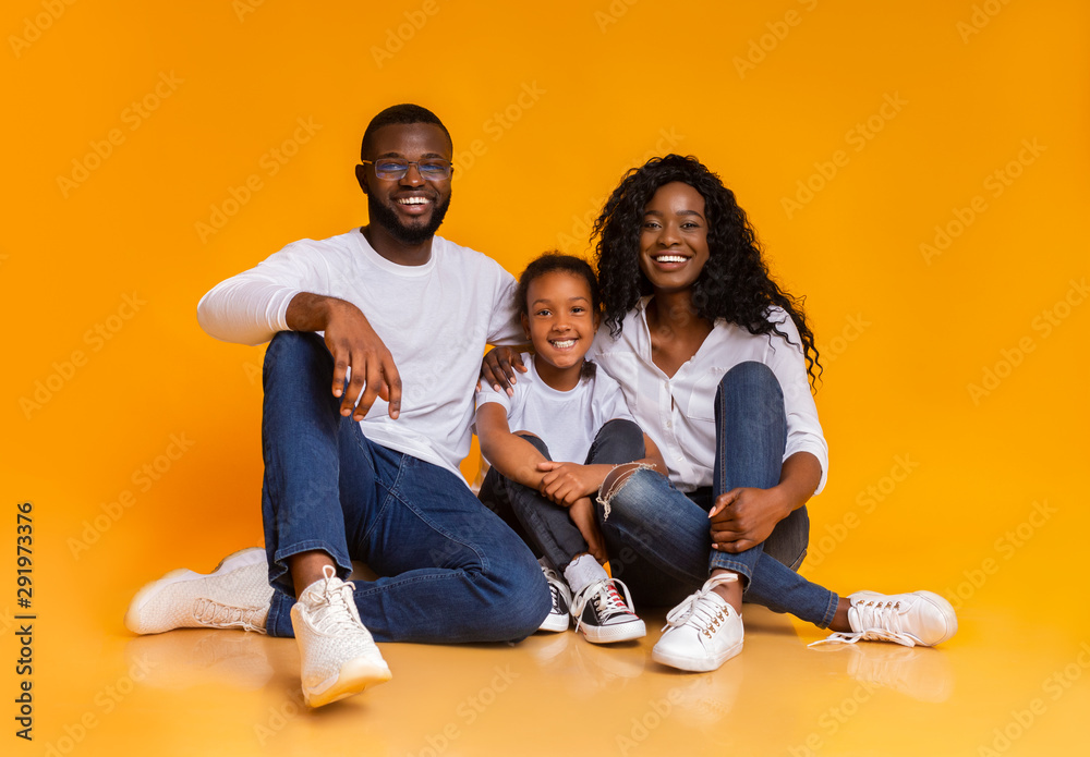 Portrait of happy black family smiling over yellow studio background Portrait of happy black family smiling over yellow studio background