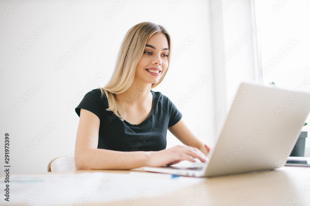 Pretty business freelancer woman working on her computer. Girl at her workspace. Start-up office background Pretty business freelancer woman working on her computer. Girl at her workspace. Start-up office background