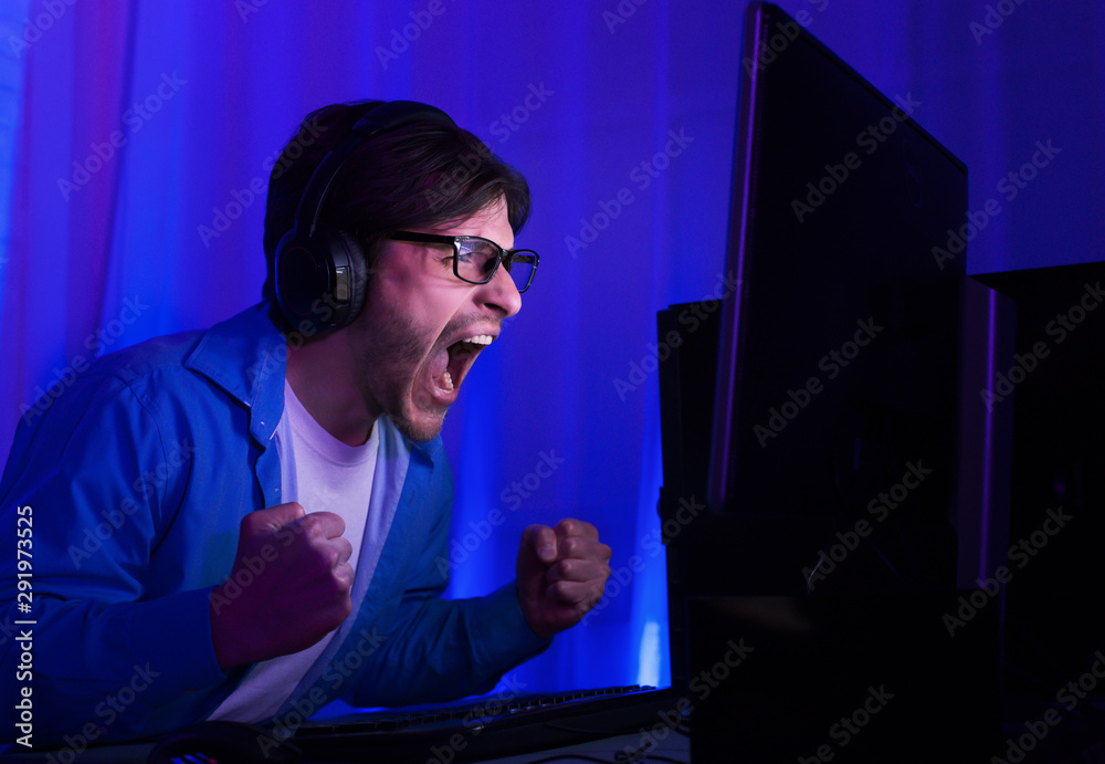 Gaming concept. Happy man in glasses celebrating victory in game Gaming concept. Happy man in glasses celebrating victory in game