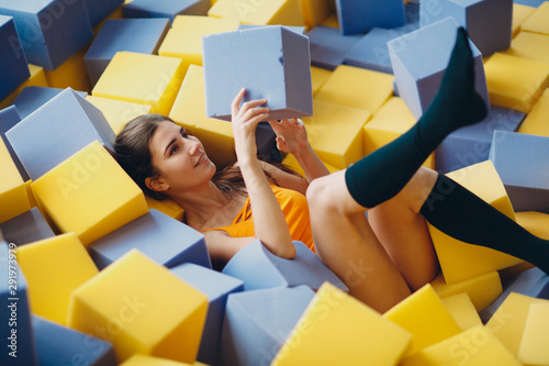 Young and beautiful woman plays in dry pool with cubes photo