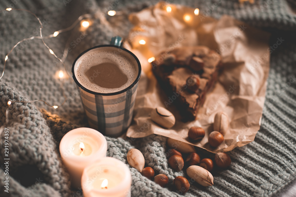 Cozy atmosphere with hot chocolate and piece of cake on knitted sweater at night closeup. Winter holiday season. Still life. Cozy atmosphere with hot chocolate and piece of cake on knitted sweater at night closeup. Winter holiday season. Still life.