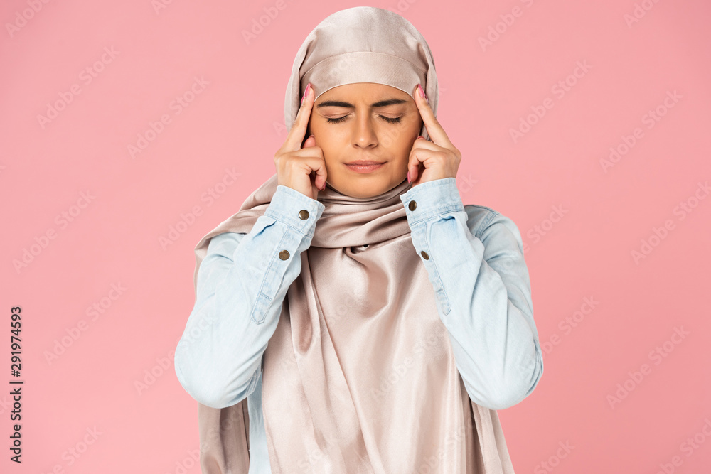 attractive arabic girl in hijab having headache, isolated on pink attractive arabic girl in hijab having headache, isolated on pink