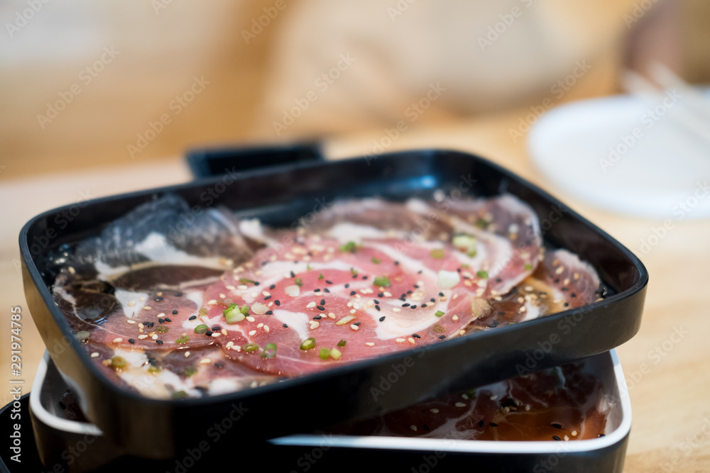 Raw beef being prepared on black tray , cooking meat Raw beef being prepared on black tray , cooking meat