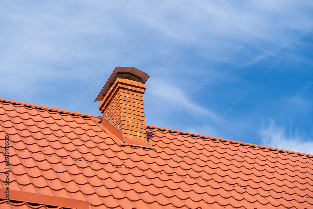 Red roof of a detached house and chimney against the blue sky, closeup Red roof of a detached house and chimney against the blue sky, closeup