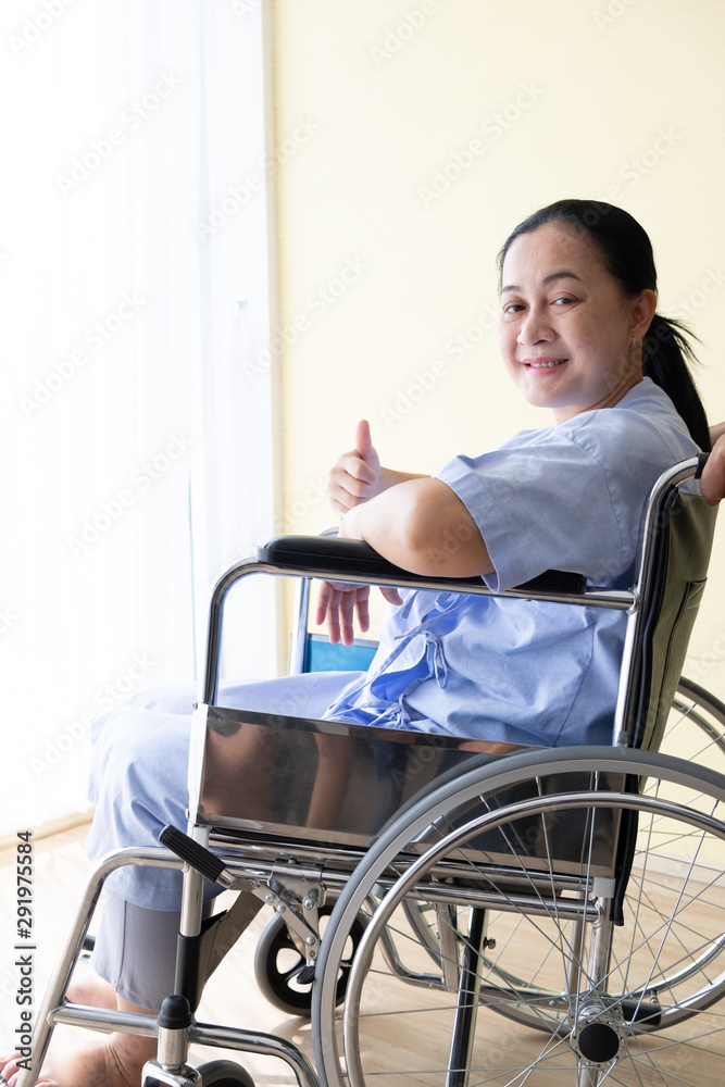 Patient sitting in a wheelchair with good encouragement, She lifted her finger and smiled. Patient sitting in a wheelchair with good encouragement, She lifted her finger and smiled.