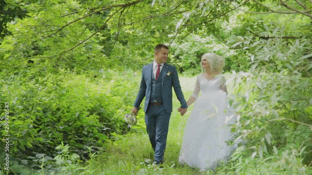 Very beautiful bride and groom hold hands and hug in the forest. Very beautiful bride and groom hold hands and hug in the forest.
