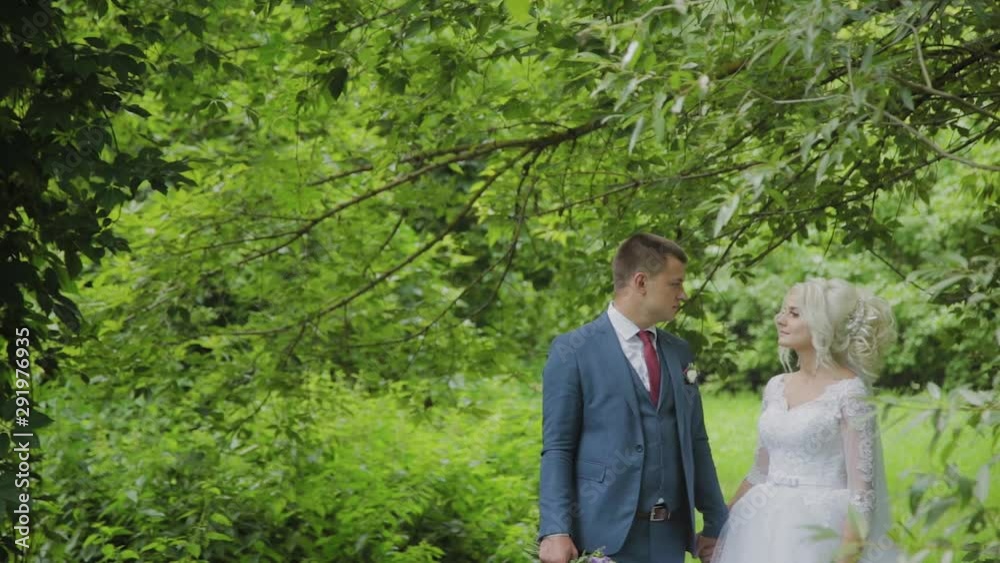 Very beautiful bride and groom hold hands and hug in the forest. Very beautiful bride and groom hold hands and hug in the forest.
