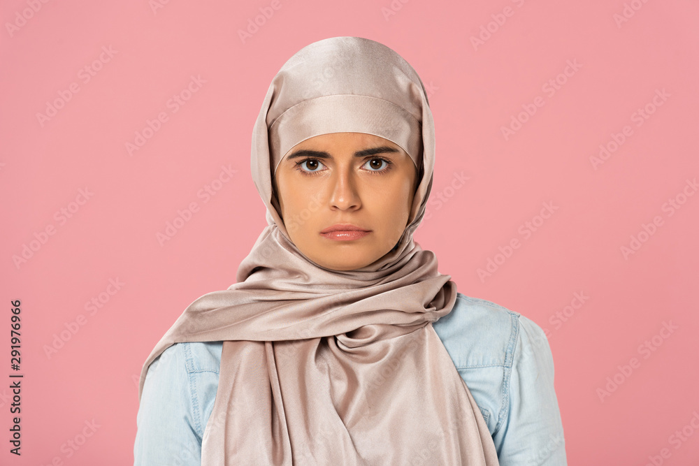 beautiful serious muslim girl in hijab, isolated on pink beautiful serious muslim girl in hijab, isolated on pink