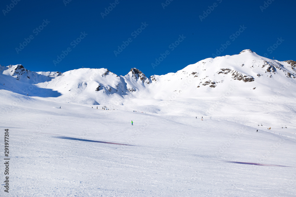 Wide ski slope in Soelden, Tirol, Austria. Alpine mountiines, covered with snow. Bright sunny day with blue sky. 